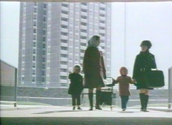 A still from a video shows two young women and their children walking in front of the Ballymun flats when they were new