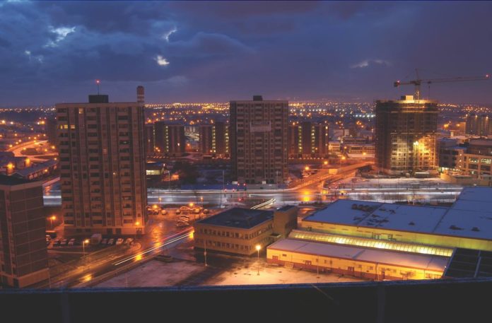 The Ballymun towers at night with Dublin City stretching out behind.