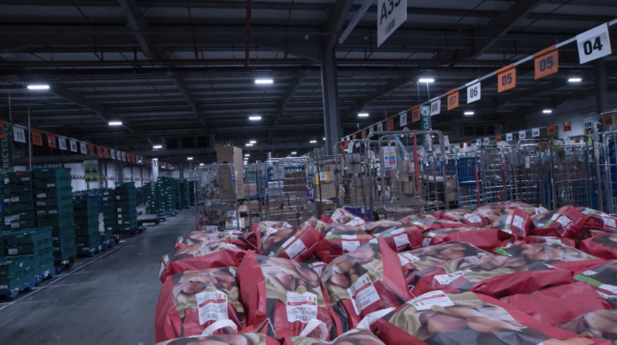 An image of a warehouse with bags of potatoes in the foreground.